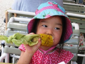 Girl likes corn. "Yummy!"